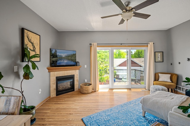 1358 Phalen Blvd, Saint Paul, MN 55106 - living area featuring wood finished floors, a tile fireplace, and ceiling fan