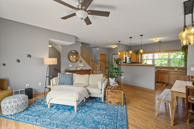 1358 Phalen Blvd, Saint Paul, MN 55106 - living area with light wood finished floors, stairway, and a ceiling fan