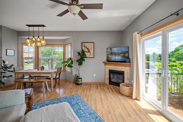 1358 Phalen Blvd, Saint Paul, MN 55106 - living area featuring a tiled fireplace, wood finished floors, a ceiling fan, and a chandelier