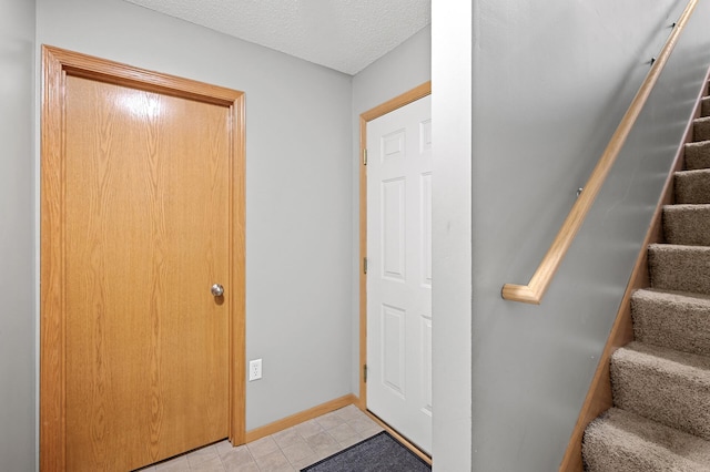 1358 Phalen Blvd, Saint Paul, MN 55106 - foyer with stairway, light tile patterned floors, and a textured ceiling