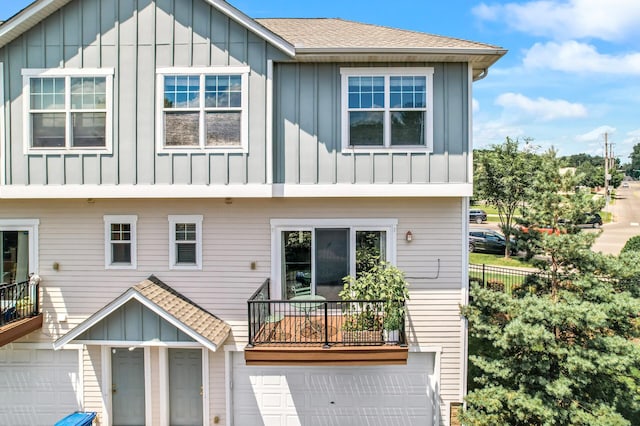 1358 Phalen Blvd, Saint Paul, MN 55106 - view of front of property featuring board and batten siding, a garage, a balcony, and a shingled roof