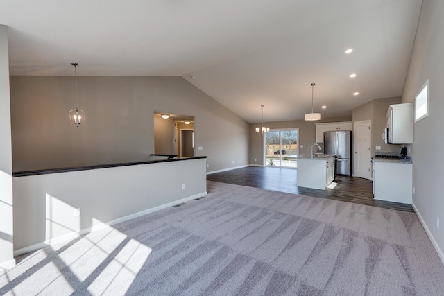 625 47th Ave NE, Saint Cloud, MN 56304 - unfurnished living room featuring a chandelier, dark colored carpet, lofted ceiling, and recessed lighting