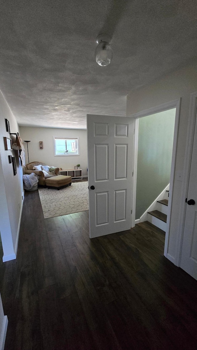 1515 3rd Ave NE, Owatonna, MN 55060 - hallway with dark wood-type flooring, a textured ceiling, and stairs