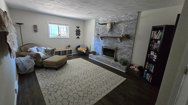 1515 3rd Ave NE, Owatonna, MN 55060 - living room featuring a brick fireplace, wood finished floors, and a textured ceiling