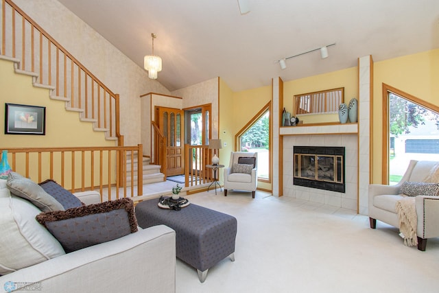 2902 24th Ave S, Fargo, ND 58103 - living room with healthy amount of natural light, carpet flooring, stairs, a tiled fireplace, and lofted ceiling