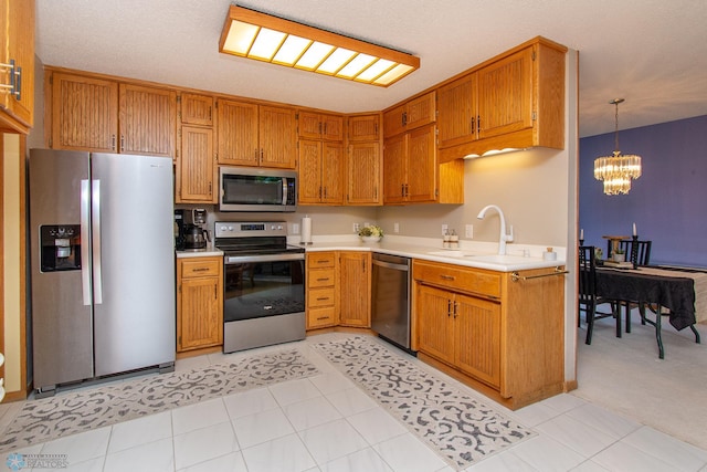 2902 24th Ave S, Fargo, ND 58103 - kitchen featuring stainless steel appliances, light countertops, a chandelier, and brown cabinets