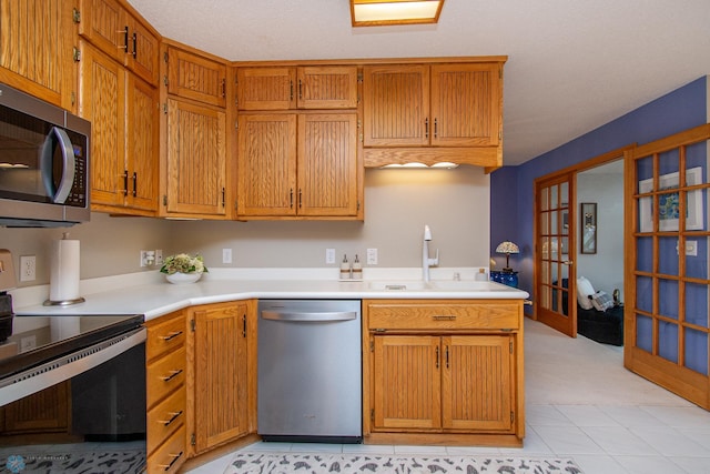 2902 24th Ave S, Fargo, ND 58103 - kitchen with stainless steel appliances, light countertops, french doors, and brown cabinetry