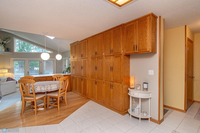 2902 24th Ave S, Fargo, ND 58103 - dining space with a skylight, vaulted ceiling, light wood-type flooring, and a textured ceiling