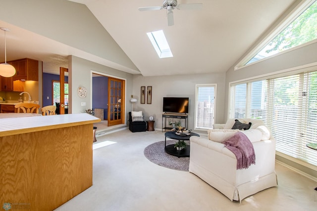 2902 24th Ave S, Fargo, ND 58103 - living room with light carpet, ceiling fan, high vaulted ceiling, and a skylight