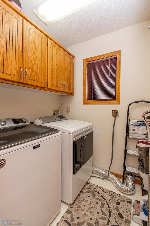2902 24th Ave S, Fargo, ND 58103 - laundry area featuring cabinet space, washer and dryer, and light tile patterned floors