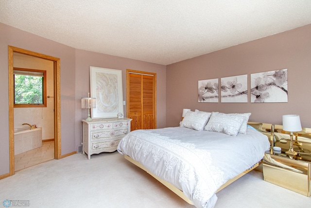 2902 24th Ave S, Fargo, ND 58103 - bedroom featuring a closet, light carpet, ensuite bath, and a textured ceiling
