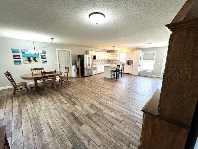 46313 St Lawrence Dr, Otto Twp, MN 56573 - dining area featuring a chandelier, dark wood-type flooring, and a textured ceiling