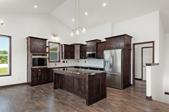 11039 285th Ave, Zimmerman, MN 55398 - kitchen featuring appliances with stainless steel finishes, high vaulted ceiling, dark brown cabinetry, decorative backsplash, and a kitchen island