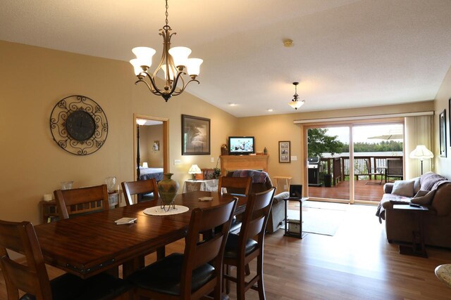 410 Pospeck Ln, Hoyt Lakes, MN 55750 - dining space featuring wood finished floors, vaulted ceiling, and a chandelier