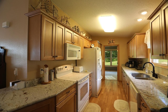 410 Pospeck Ln, Hoyt Lakes, MN 55750 - kitchen featuring white appliances, light wood finished floors, light stone counters, a textured ceiling, and brown cabinets