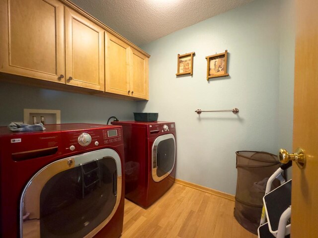 410 Pospeck Ln, Hoyt Lakes, MN 55750 - washroom with cabinet space, washing machine and dryer, light wood-style flooring, and a textured ceiling
