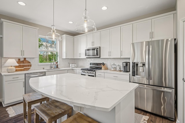 3702 112th Cir NE, Blaine, MN 55449 - kitchen with appliances with stainless steel finishes, dark wood-type flooring, recessed lighting, a breakfast bar area, and white cabinetry