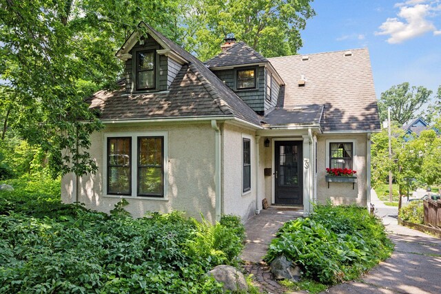 73 Arthur Ave SE, Minneapolis, MN 55414 - view of front of house with stucco siding, roof with shingles, and a chimney