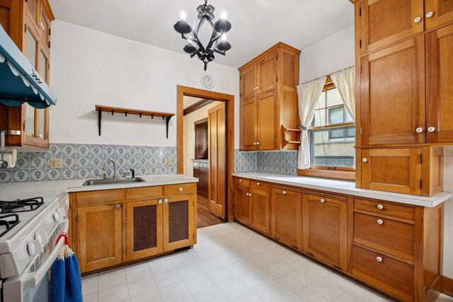 73 Arthur Ave SE, Minneapolis, MN 55414 - kitchen with extractor fan, open shelves, a chandelier, light countertops, and white gas range oven