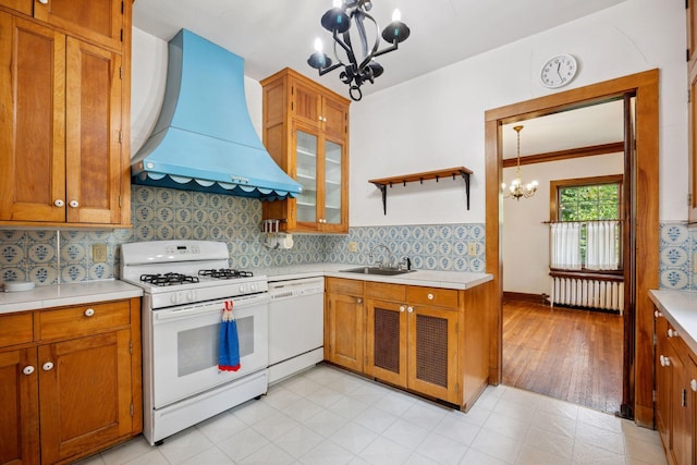 73 Arthur Ave SE, Minneapolis, MN 55414 - kitchen featuring wall chimney range hood, white appliances, a chandelier, light countertops, and brown cabinets
