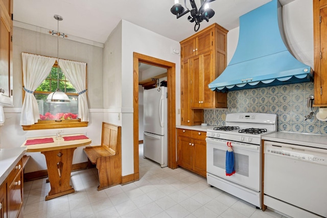 73 Arthur Ave SE, Minneapolis, MN 55414 - kitchen featuring white appliances, custom exhaust hood, light countertops, and a chandelier