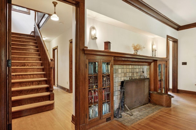 73 Arthur Ave SE, Minneapolis, MN 55414 - stairway featuring wood finished floors, crown molding, and a fireplace