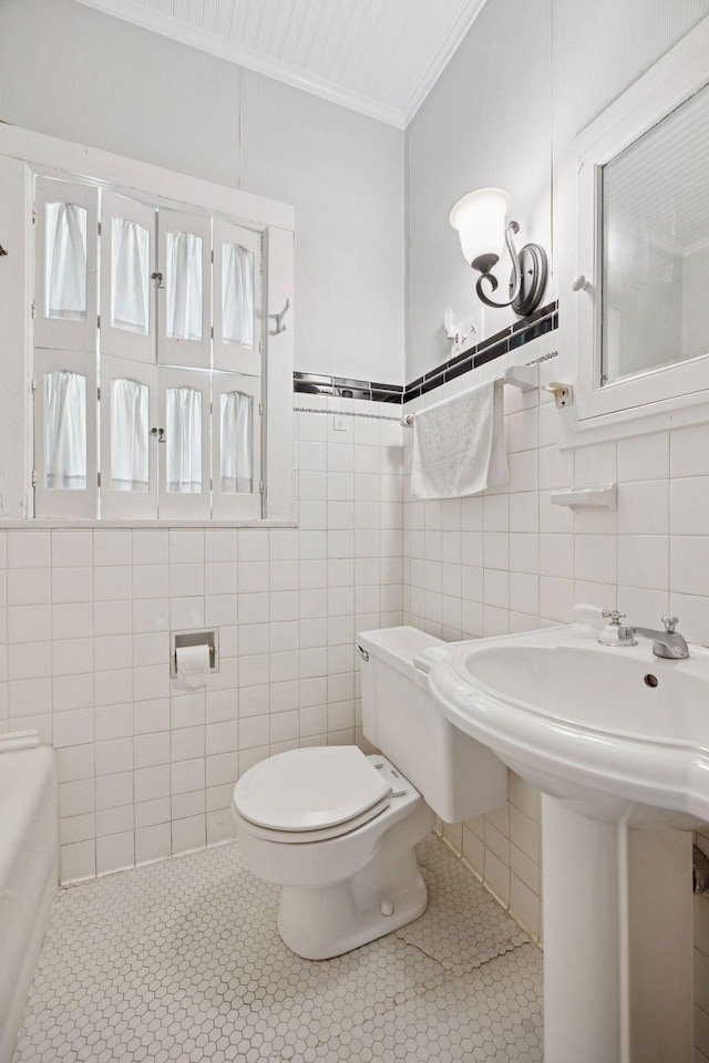 73 Arthur Ave SE, Minneapolis, MN 55414 - bathroom featuring tile walls, ornamental molding, a bathtub, and tile patterned flooring