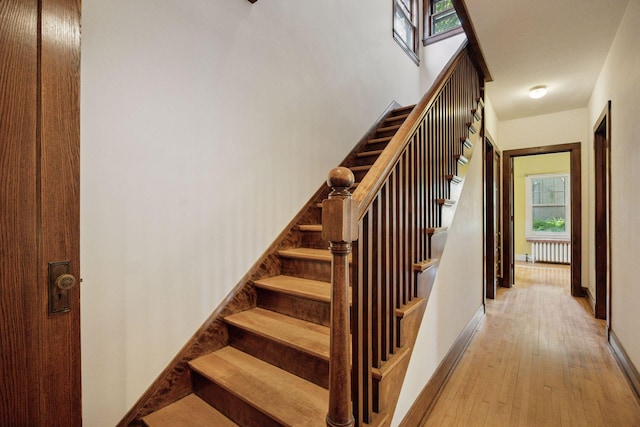 73 Arthur Ave SE, Minneapolis, MN 55414 - staircase with radiator, wood finished floors, and healthy amount of natural light
