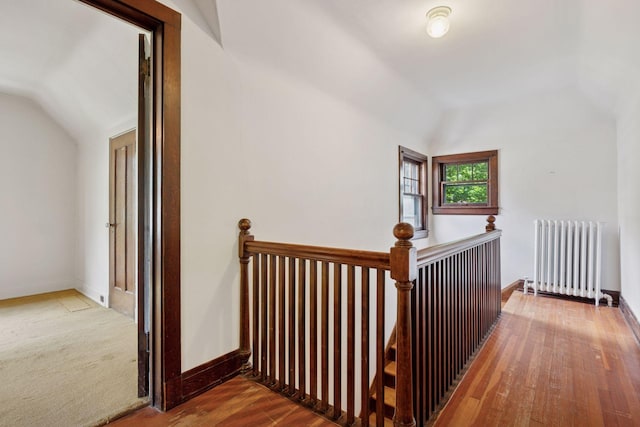 73 Arthur Ave SE, Minneapolis, MN 55414 - corridor featuring radiator, vaulted ceiling, an upstairs landing, and wood finished floors
