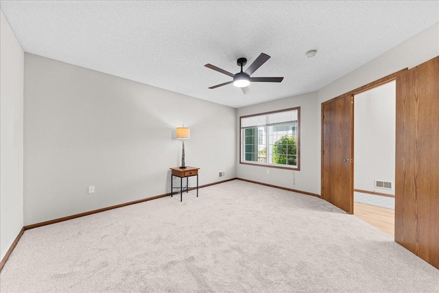 7514 Ojibway Park Rd, Woodbury, MN 55125 - unfurnished bedroom featuring light carpet, a textured ceiling, and ceiling fan