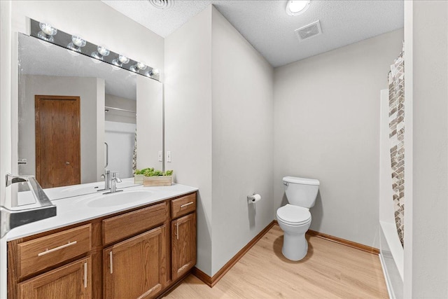 7514 Ojibway Park Rd, Woodbury, MN 55125 - bathroom featuring vanity, wood finished floors, a textured ceiling, and shower / bathtub combination with curtain