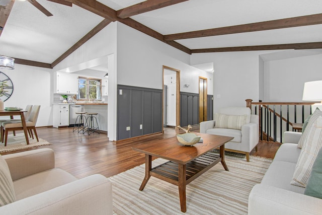 7401 River Shore Ln, Champlin, MN 55316 - living area with light wood-style flooring, a ceiling fan, and a wainscoted wall