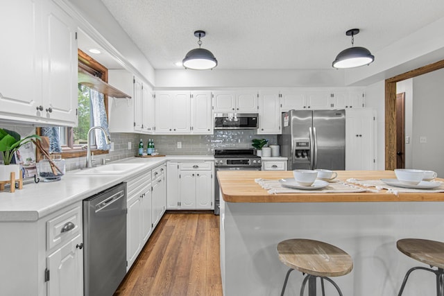 7401 River Shore Ln, Champlin, MN 55316 - kitchen with appliances with stainless steel finishes, white cabinets, dark wood finished floors, and a textured ceiling