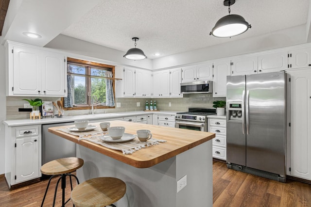 7401 River Shore Ln, Champlin, MN 55316 - kitchen with stainless steel appliances, white cabinets, dark wood-style floors, a textured ceiling, and recessed lighting