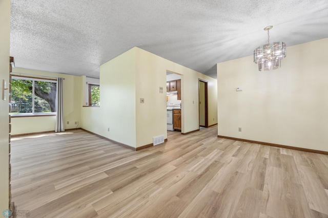 3237 17th Ave S Unit 101, Fargo, ND 58103 - unfurnished living room featuring a textured ceiling, light wood-type flooring, and a chandelier