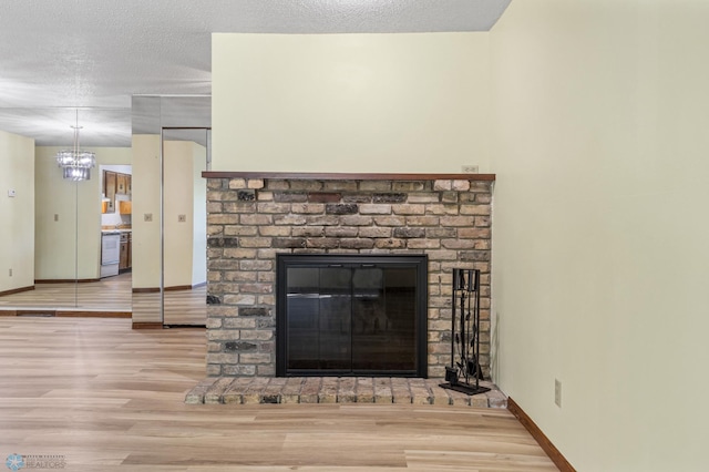 3237 17th Ave S Unit 101, Fargo, ND 58103 - detailed view of wood finished floors, a fireplace, a chandelier, and a textured ceiling