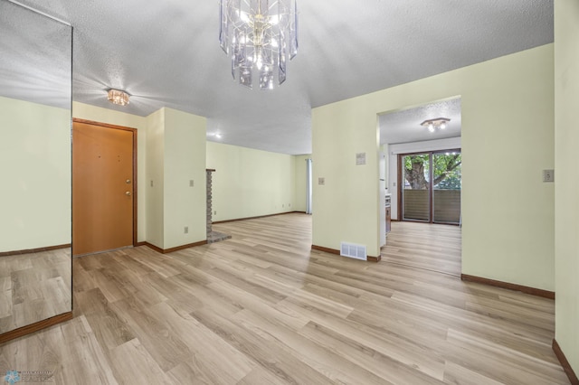 3237 17th Ave S Unit 101, Fargo, ND 58103 - spare room featuring light wood-style flooring and a textured ceiling