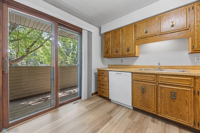 3237 17th Ave S Unit 101, Fargo, ND 58103 - kitchen featuring white dishwasher, brown cabinets, light wood finished floors, a textured ceiling, and butcher block counters