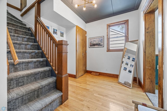 726 Oak St N, Fargo, ND 58102 - stairs featuring hardwood / wood-style flooring, a chandelier, and crown molding