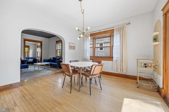 726 Oak St N, Fargo, ND 58102 - dining area with arched walkways, light wood-type flooring, and a chandelier