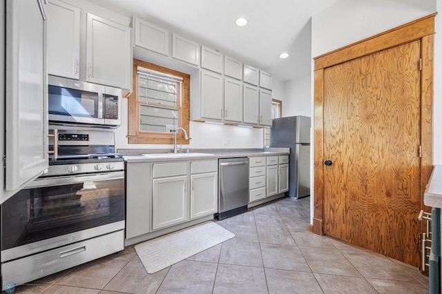 726 Oak St N, Fargo, ND 58102 - kitchen featuring stainless steel appliances, light countertops, light tile patterned flooring, recessed lighting, and white cabinetry