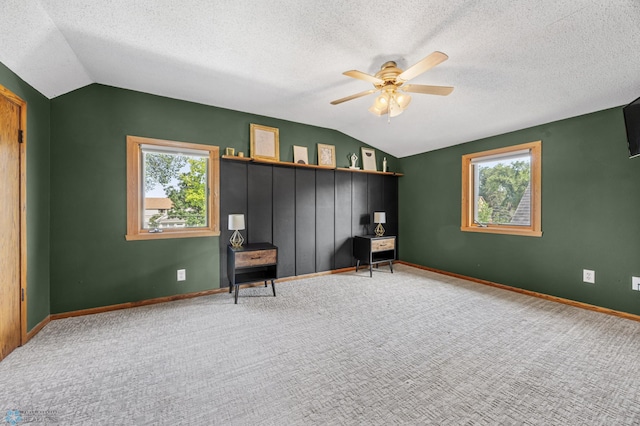 726 Oak St N, Fargo, ND 58102 - living area with vaulted ceiling, a ceiling fan, carpet floors, and a textured ceiling