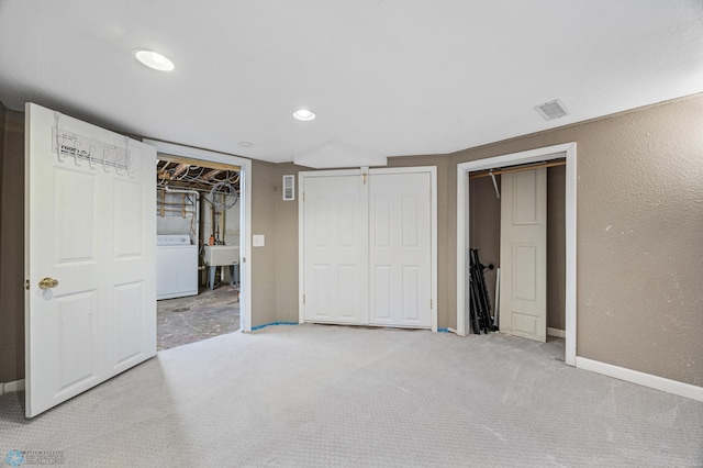 726 Oak St N, Fargo, ND 58102 - unfurnished bedroom with washer / clothes dryer, two closets, carpet flooring, recessed lighting, and a textured wall