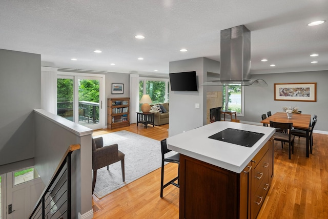 4832 Longford Rd, Mound, MN 55364 - kitchen featuring black electric cooktop, island range hood, a kitchen island, light wood-type flooring, and recessed lighting