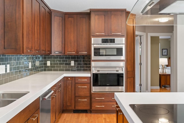 4832 Longford Rd, Mound, MN 55364 - kitchen featuring stainless steel appliances, light countertops, backsplash, range hood, and light wood-type flooring