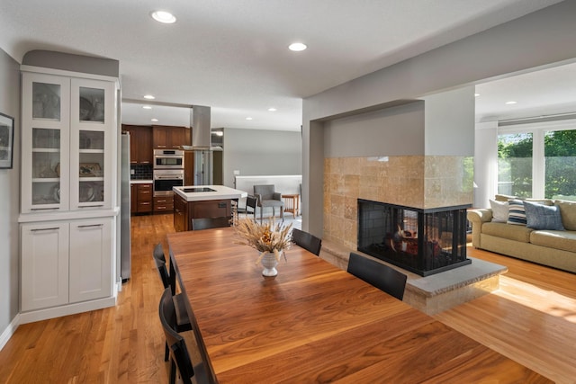 4832 Longford Rd, Mound, MN 55364 - dining space featuring recessed lighting, light wood-style flooring, and a tiled fireplace
