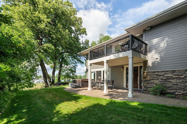 4832 Longford Rd, Mound, MN 55364 - rear view of property featuring a hot tub, a balcony, a patio, a yard, and stone siding