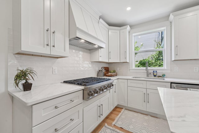 109 Pine St E, Stillwater, MN 55082 - kitchen featuring premium range hood, light wood-type flooring, white cabinets, appliances with stainless steel finishes, and recessed lighting