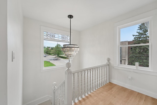 109 Pine St E, Stillwater, MN 55082 - corridor featuring an upstairs landing, plenty of natural light, a chandelier, and wood finished floors