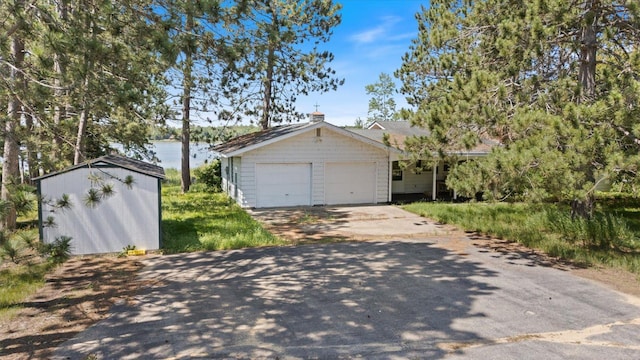21837 Mishawaka Rd, Grand Rapids, MN 55744 - garage with a storage shed, driveway, and a water view